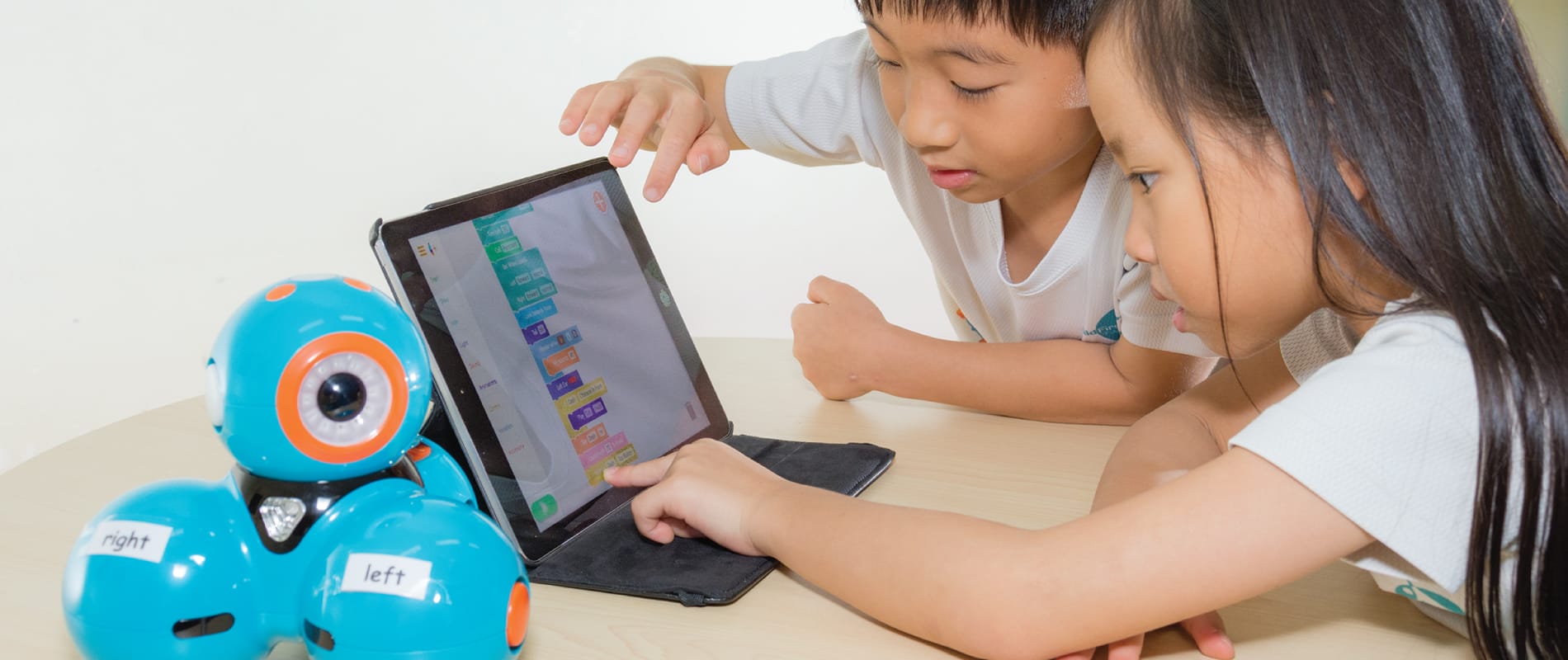 Children engaged in coding and robotics activities at ChildFirst Pre-School